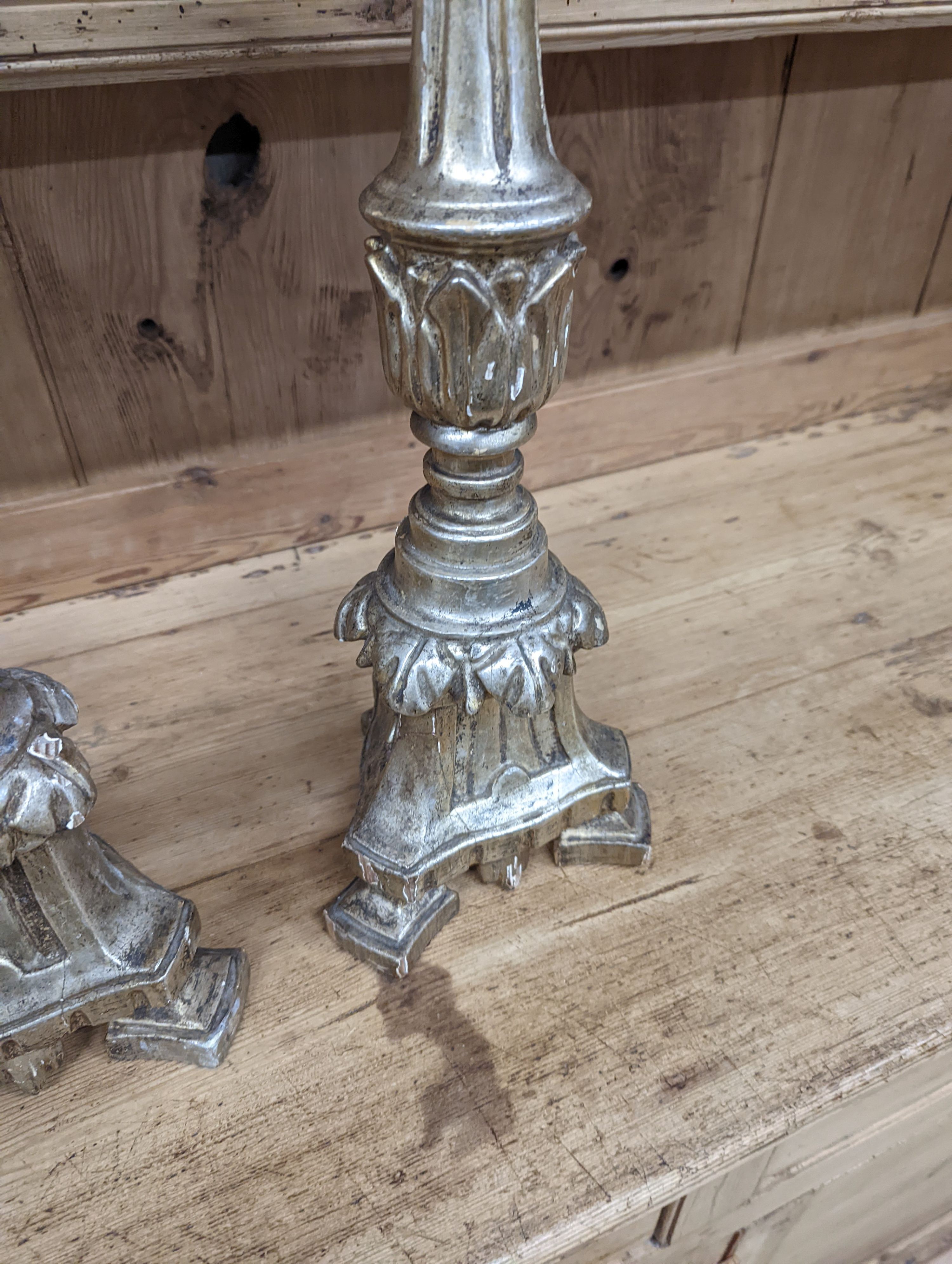 A pair of 18th century style carved silvered wood candlesticks, height 58cm